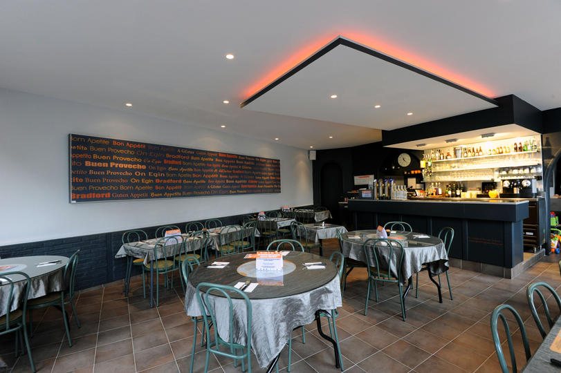 La salle du Bradford dressée en tables rondes, avec le bar en arrière-plan