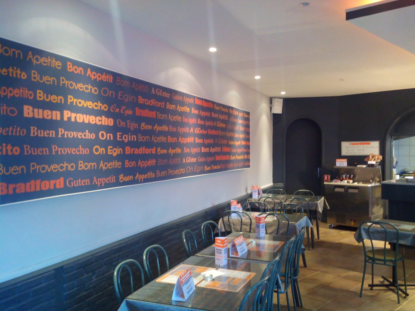 La salle du restaurant Au Bradford, avec sa fresque murale bleue et orange